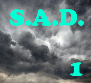S.A.D. 1 est écrit en tuquoise, sur un ciel de gros nuages sombres 1